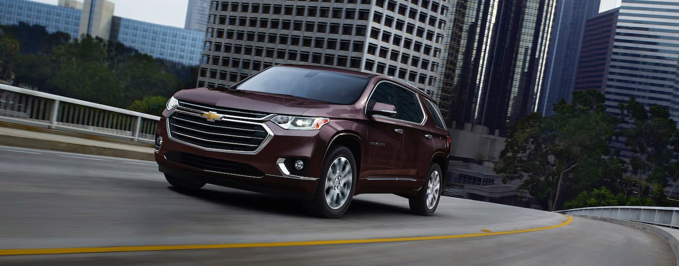 A maroon 2020 Chevy Traverse is shown driving on a city street.