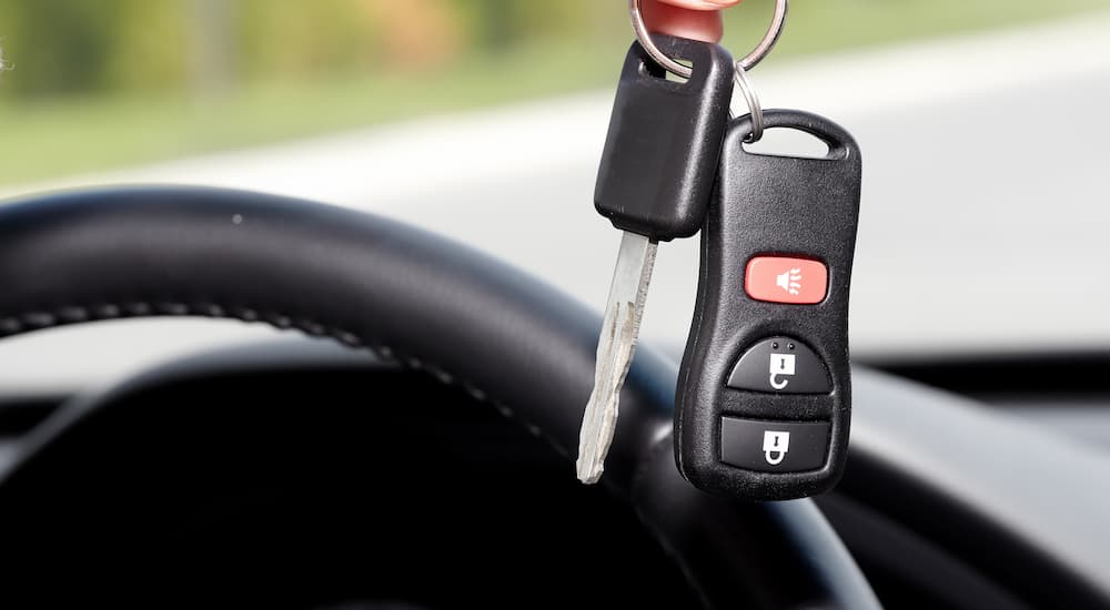 A set of car keys are shown in a vehicle after reviewing paperwork for bad credit auto loans near Charlotte, MI.