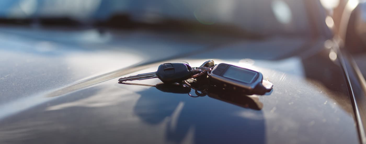A set of car keys is shown on the hood of a vehicle at a used car lot near Grand Ledge.