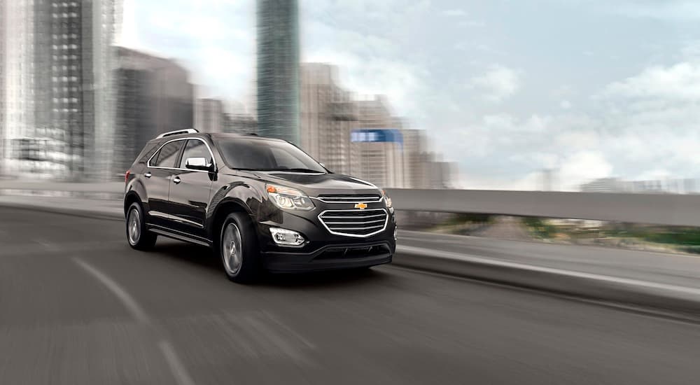 A black 2015 Chevy Equinox is shown driving on a highway.