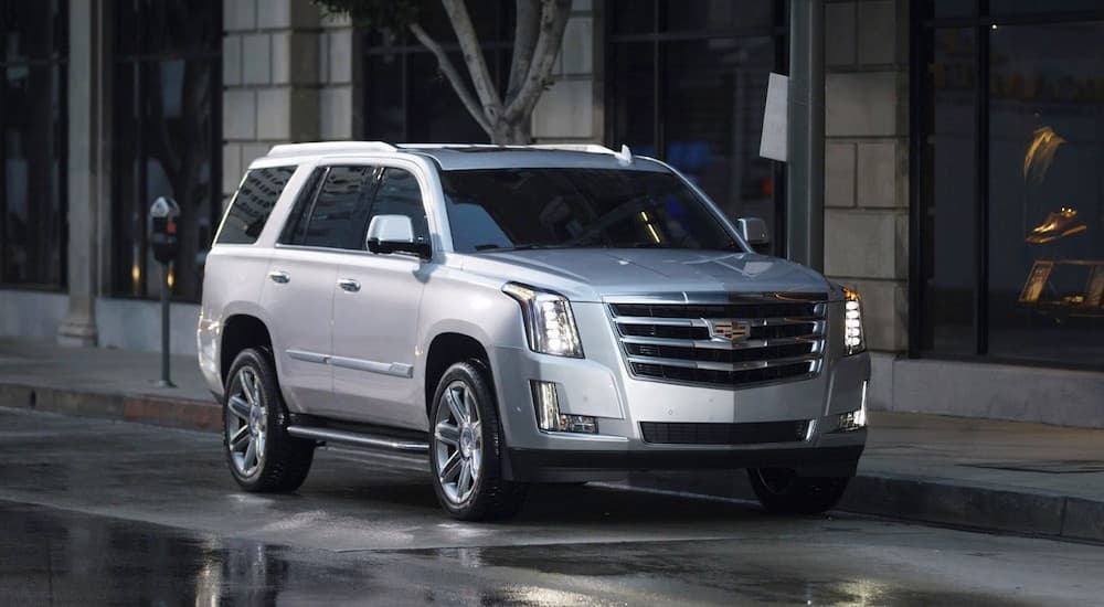 A silver 2016 Cadillac Escalade is shown parked on the side of a city street.